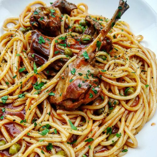 Spaghetti with traditional local rabbit, tomato sauce, peas and garlic