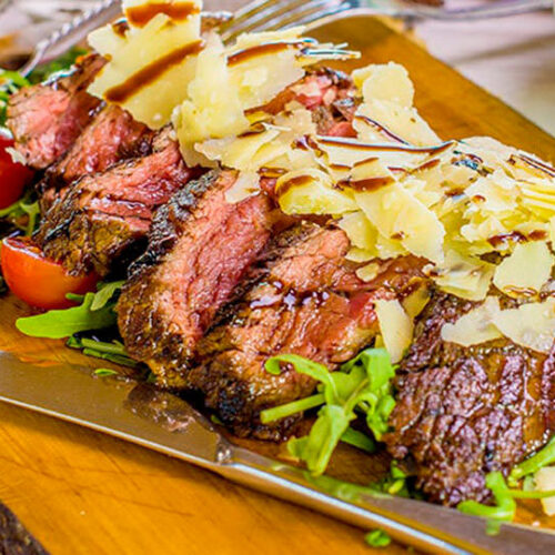 Thick steak, grilled then carved into thin slices and served on a bed of rucola, topped with grana shavings