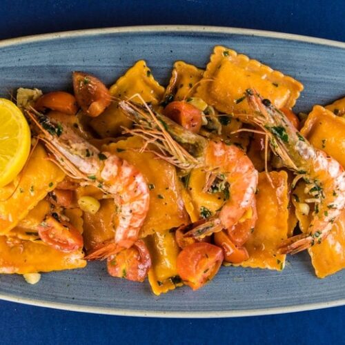 Salmon and ricotta filled ravioli, served with medium prawns and cherry tomatoes cooked in white wine, homemade olive oil and garlic
